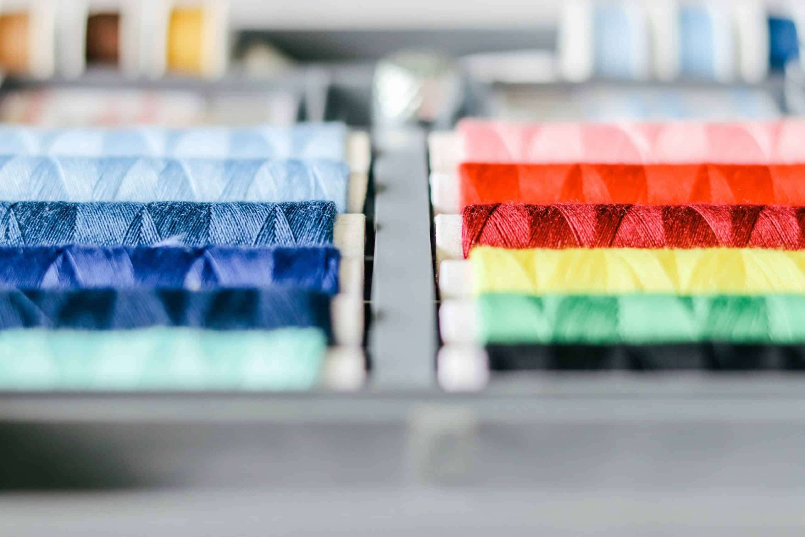 Bobines de fil de couture multicolores alignées en dégradé